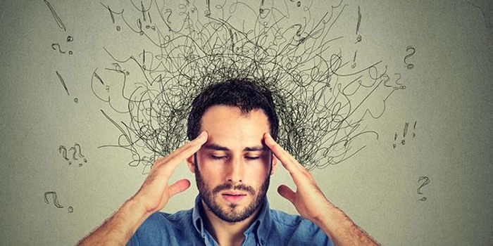 Erkek baş ağrısıyla düşünceli, kaotik soru işaretleri etrafında uçuşuyor. Online psikolojik destek için idealdir.
